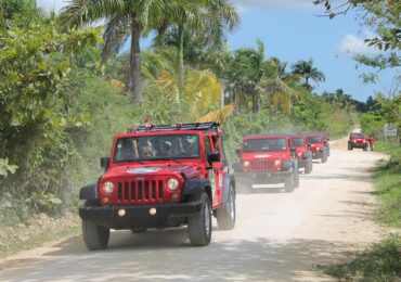 two people outside of a jeep in a tour