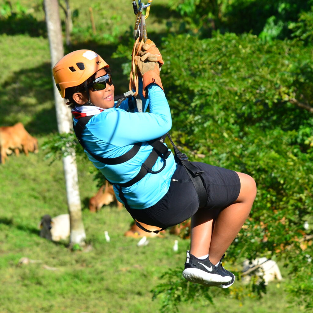 a person in a zip line with a farm backround in hacienda