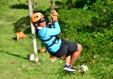 a person in a zip line with a farm backround in hacienda